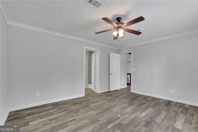 spare room featuring a ceiling fan, wood finished floors, baseboards, and ornamental molding