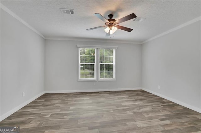 empty room featuring a ceiling fan, wood finished floors, a textured ceiling, baseboards, and ornamental molding