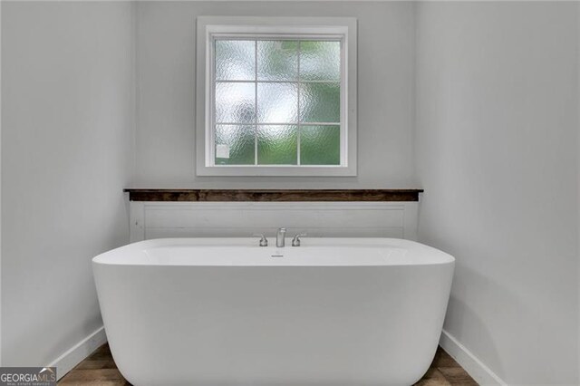 full bathroom with baseboards and a freestanding bath