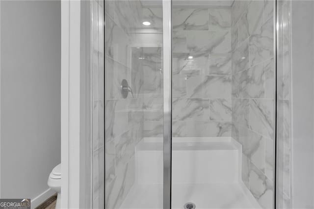 full bath featuring a marble finish shower and toilet