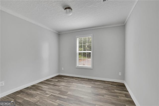 unfurnished room featuring wood finished floors, a textured ceiling, baseboards, and ornamental molding