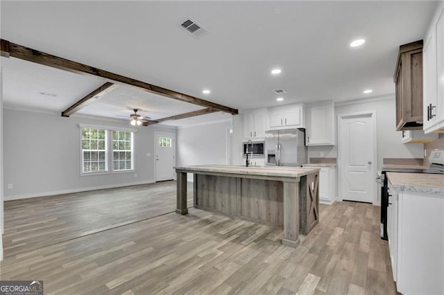 kitchen featuring appliances with stainless steel finishes, light wood-style floors, baseboards, white cabinets, and ceiling fan