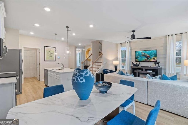 dining room with ceiling fan, stairway, light wood-type flooring, and recessed lighting