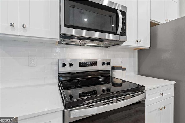 kitchen featuring stainless steel appliances, light countertops, white cabinetry, tasteful backsplash, and wood finished floors