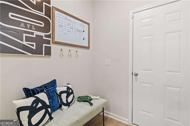 living area with baseboards and wood finished floors