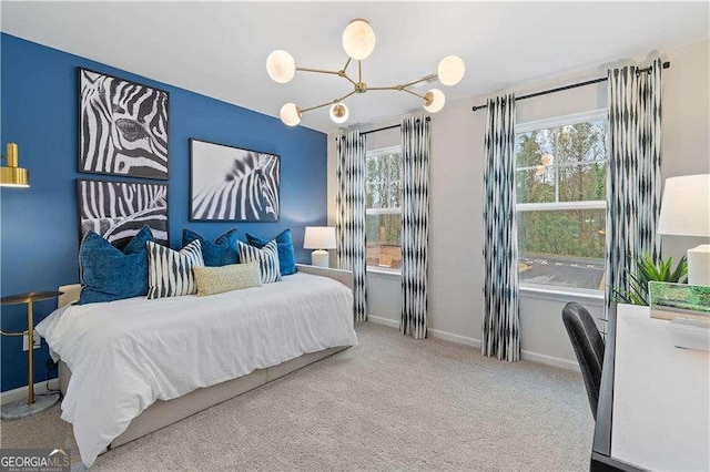 carpeted bedroom with multiple windows, a chandelier, and baseboards