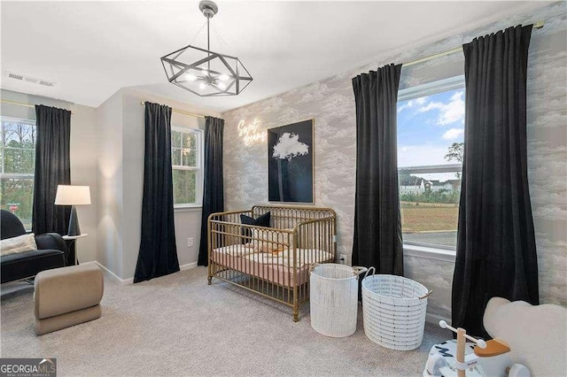 bedroom with baseboards, wallpapered walls, multiple windows, a chandelier, and carpet floors