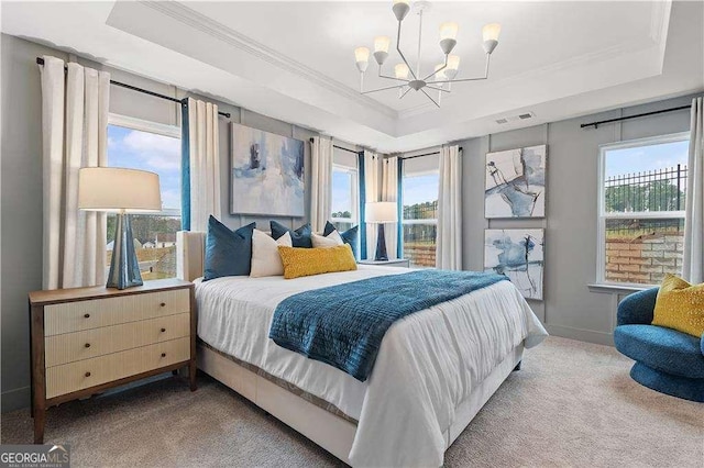 bedroom with a tray ceiling, carpet floors, ornamental molding, a chandelier, and baseboards