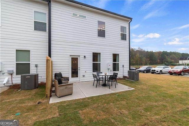 back of house featuring central AC unit, a lawn, and a patio area