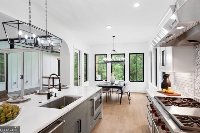2595 Grassview Dr, Milton, GA 30004 - kitchen featuring appliances with stainless steel finishes, a chandelier, a sink, recessed lighting, and exhaust hood