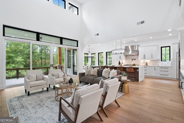 2595 Grassview Dr, Milton, GA 30004 - living room featuring light wood-type flooring, plenty of natural light, a high ceiling, recessed lighting, and a chandelier
