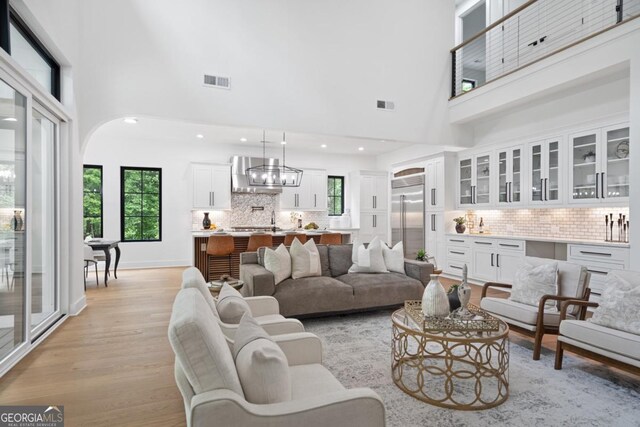 2595 Grassview Dr, Milton, GA 30004 - living area with a chandelier, a towering ceiling, light wood finished floors, recessed lighting, and arched walkways