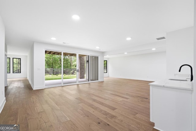 2595 Grassview Dr, Milton, GA 30004 - unfurnished living room with a sink, light wood-style flooring, baseboards, and recessed lighting