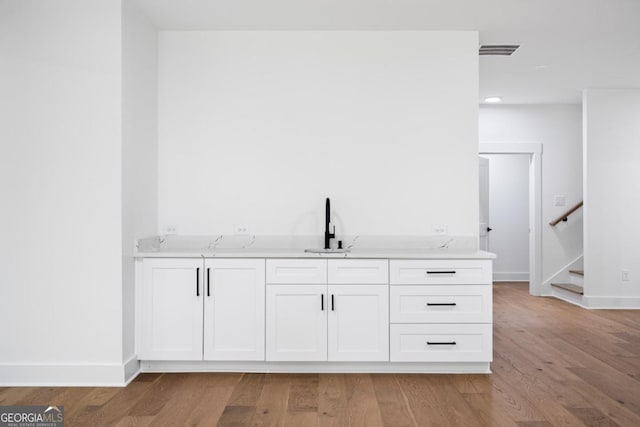 2595 Grassview Dr, Milton, GA 30004 - bar with a sink, light wood-type flooring, stairs, baseboards, and recessed lighting