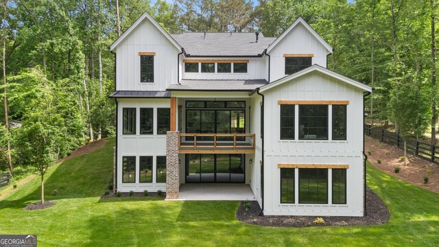 2595 Grassview Dr, Milton, GA 30004 - rear view of house featuring roof with shingles, a patio, board and batten siding, and a standing seam roof