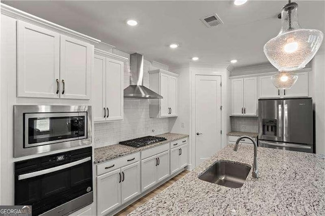 5121 Aster Bnd, Canton, GA 30114 - kitchen with appliances with stainless steel finishes, a sink, wall chimney exhaust hood, white cabinetry, and recessed lighting
