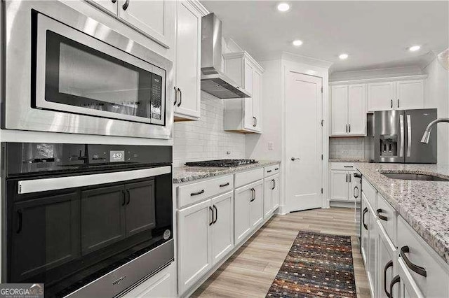 5121 Aster Bnd, Canton, GA 30114 - kitchen featuring stainless steel appliances, wall chimney range hood, a sink, white cabinetry, and recessed lighting