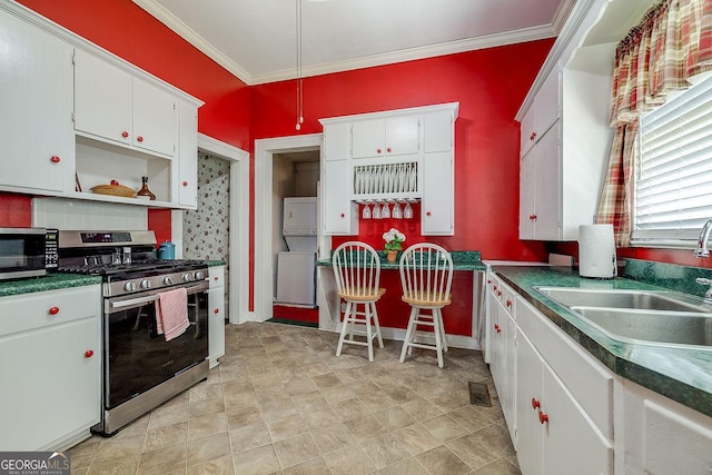 120 Newton St, Pooler, GA 31322 - kitchen featuring appliances with stainless steel finishes, stacked washer / dryer, white cabinets, ornamental molding, and open shelves