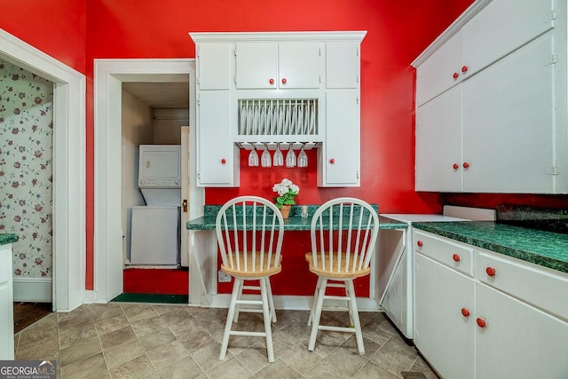 120 Newton St, Pooler, GA 31322 - kitchen with stacked washer / dryer, baseboards, white cabinets, and dark countertops