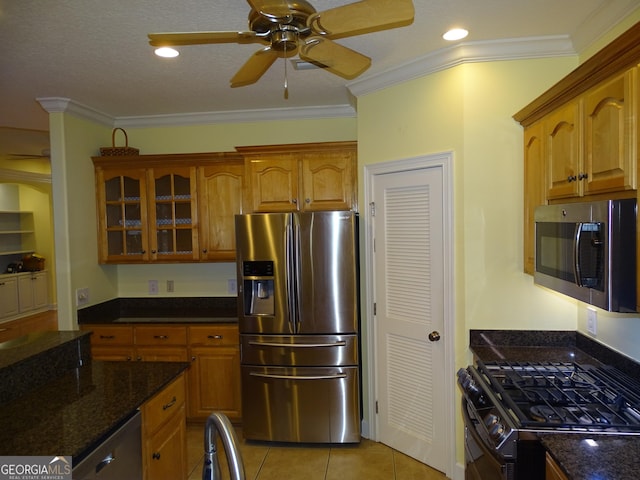 228 Laurel Landing Blvd, Kingsland, GA 31548 - kitchen with appliances with stainless steel finishes, a ceiling fan, glass insert cabinets, crown molding, and brown cabinets