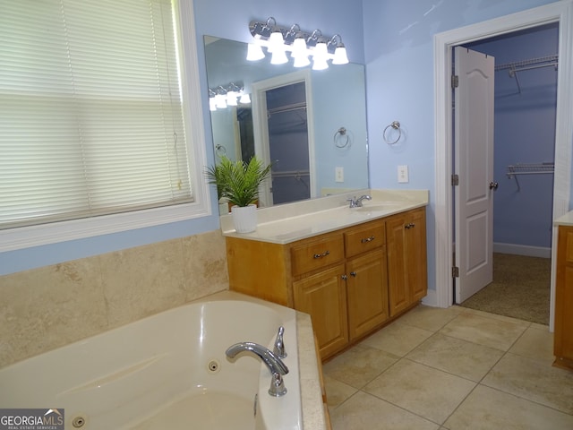 228 Laurel Landing Blvd, Kingsland, GA 31548 - bathroom with vanity, a tub with jets, a spacious closet, and tile patterned floors
