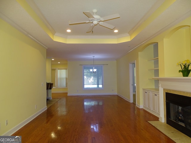 228 Laurel Landing Blvd, Kingsland, GA 31548 - unfurnished living room featuring a tray ceiling, a fireplace with flush hearth, ornamental molding, wood finished floors, and ceiling fan