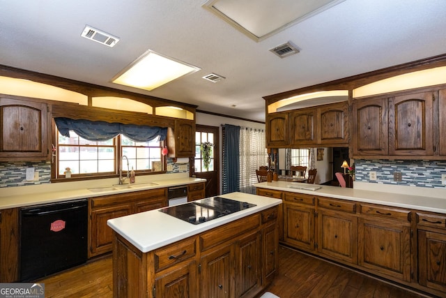 1701 City Blvd, Waycross, GA 31501 - kitchen with black appliances, light countertops, backsplash, dark wood finished floors, and a kitchen island