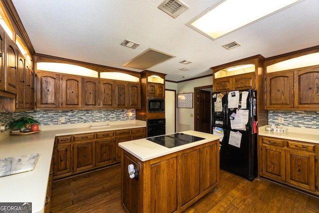1701 City Blvd, Waycross, GA 31501 - kitchen featuring black appliances, dark wood-style flooring, a kitchen island, light countertops, and ornamental molding