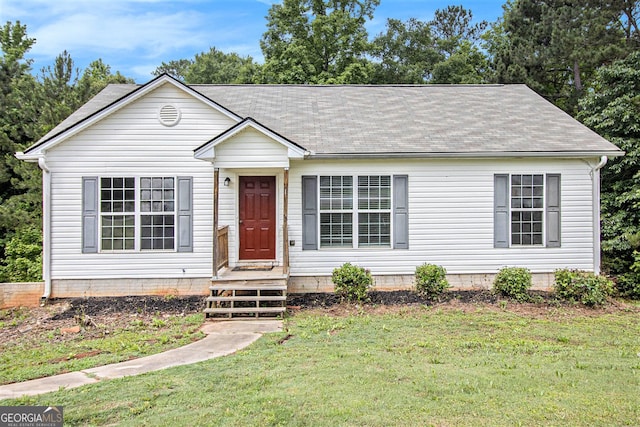 view of front facade with roof with shingles and a front lawn