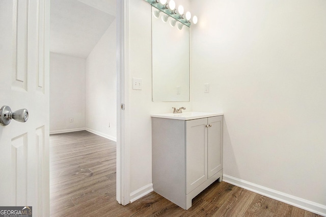 bathroom with wood finished floors, baseboards, and vanity