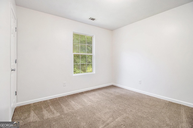 spare room featuring carpet flooring and baseboards