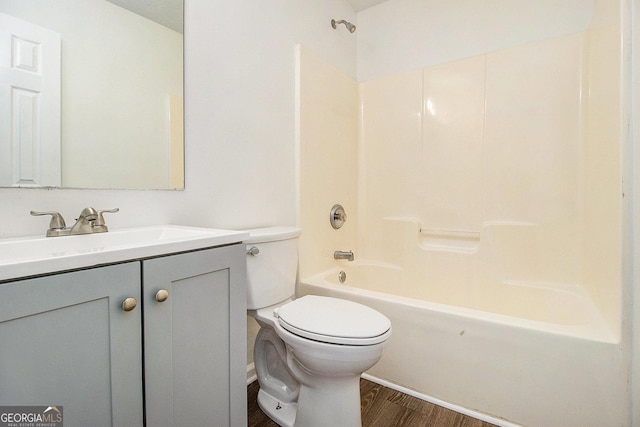 bathroom featuring wood finished floors, toilet, vanity, and tub / shower combination