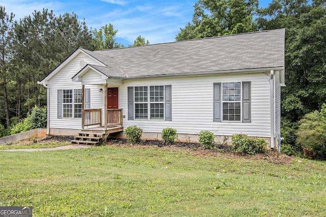 view of front of house with a front yard and a shingled roof