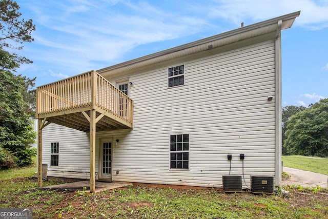 rear view of house with a wooden deck and central air condition unit