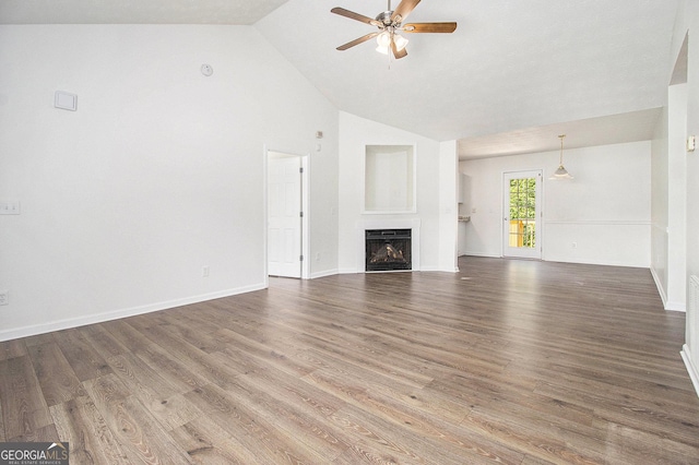unfurnished living room with ceiling fan, high vaulted ceiling, a fireplace, wood finished floors, and baseboards