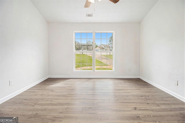 empty room featuring ceiling fan, wood finished floors, and baseboards