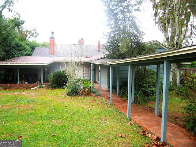 back of house with a lawn and a chimney