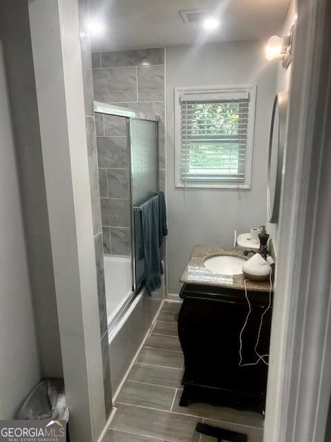 3629 Centerview Dr, Marietta, GA 30066 - bathroom featuring vanity, wood tiled floors, and combined bath / shower with glass door