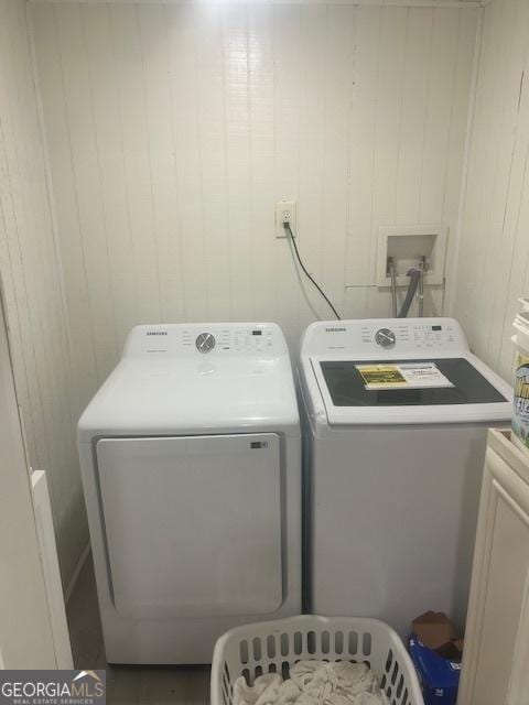 3629 Centerview Dr, Marietta, GA 30066 - laundry room featuring independent washer and dryer, cabinet space, and wood walls