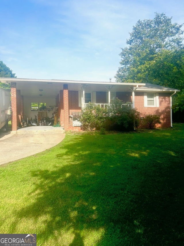 view of front of home featuring concrete driveway, a front lawn, brick siding, and a carport