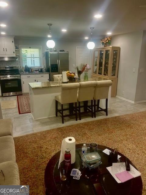 3629 Centerview Dr, Marietta, GA 30066 - kitchen featuring appliances with stainless steel finishes, white cabinets, under cabinet range hood, decorative light fixtures, and a sink