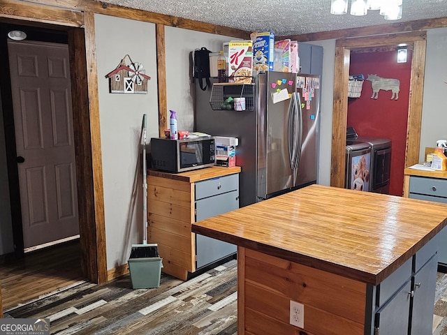 536 Gov Seay Rd, Collins, GA 30421 - kitchen with butcher block countertops, stainless steel appliances, independent washer and dryer, wood finished floors, and a textured ceiling