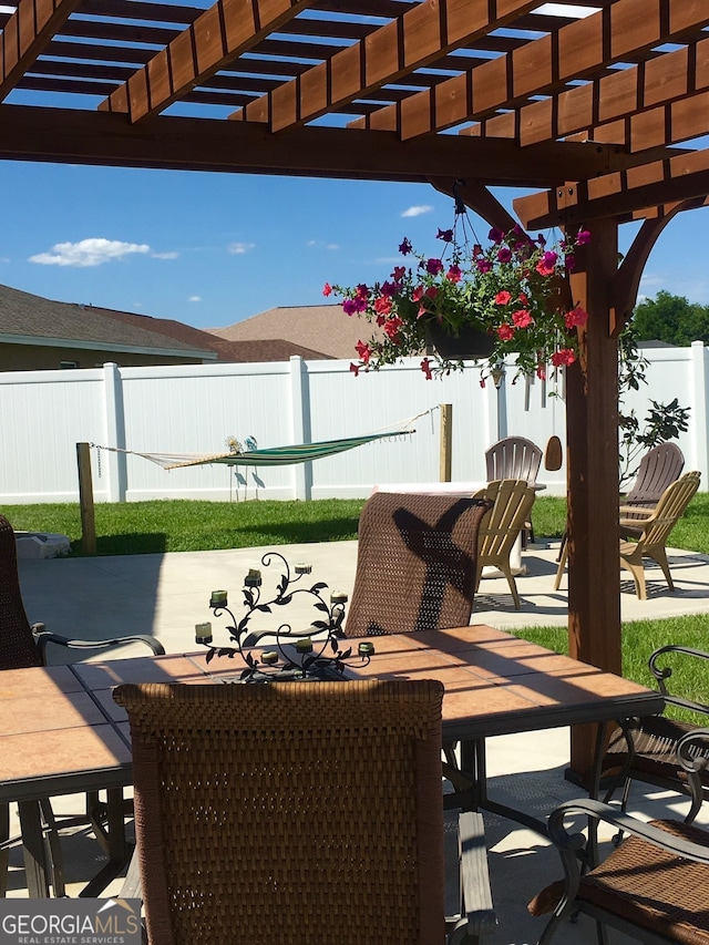 fenced backyard with outdoor dining area, a pergola, and a patio area