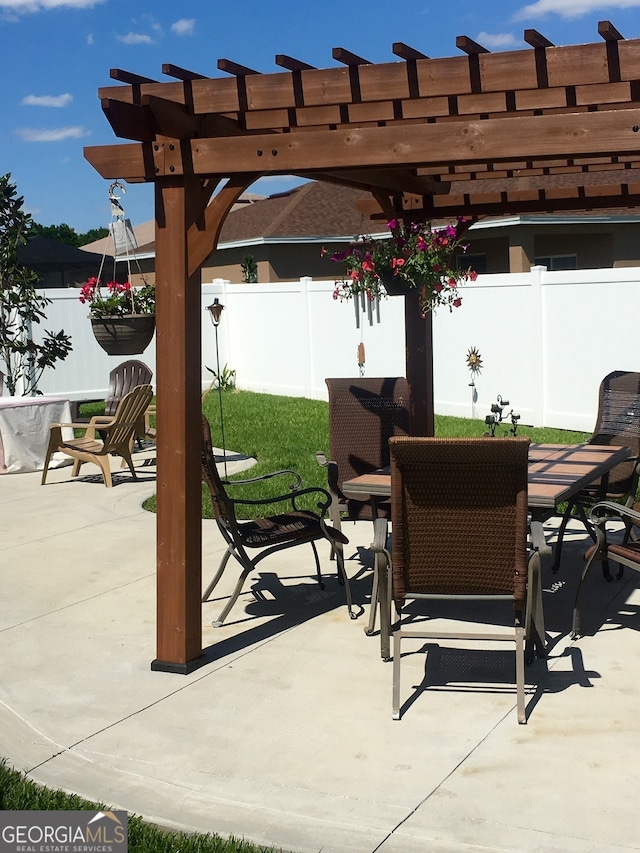 fenced backyard with outdoor dining space, a pergola, and a patio