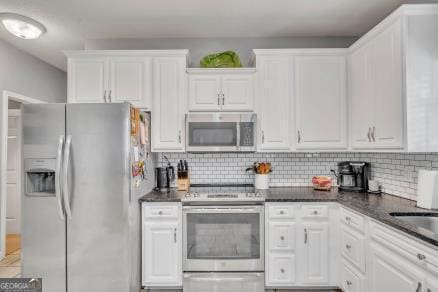 816 Tanglewood Cir, Dublin, GA 31021 - kitchen featuring appliances with stainless steel finishes, white cabinetry, dark countertops, and backsplash