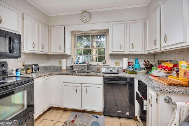 503 Marsh Cir, Saint Simons, GA 31522 - kitchen featuring black appliances, a sink, light tile patterned floors, decorative backsplash, and white cabinets
