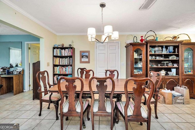 503 Marsh Cir, Saint Simons, GA 31522 - dining room with light tile patterned floors, ornamental molding, a chandelier, and a textured ceiling