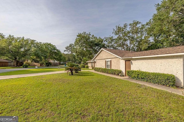 503 Marsh Cir, Saint Simons, GA 31522 - view of property exterior featuring a yard and stucco siding