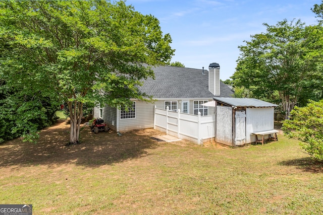14 Winter Ln, Newnan, GA 30265 - rear view of property featuring a yard, a chimney, and a shingled roof