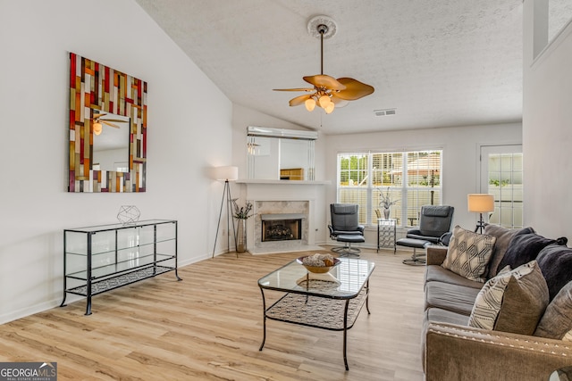 14 Winter Ln, Newnan, GA 30265 - living room with wood finished floors, lofted ceiling, a ceiling fan, a premium fireplace, and a textured ceiling